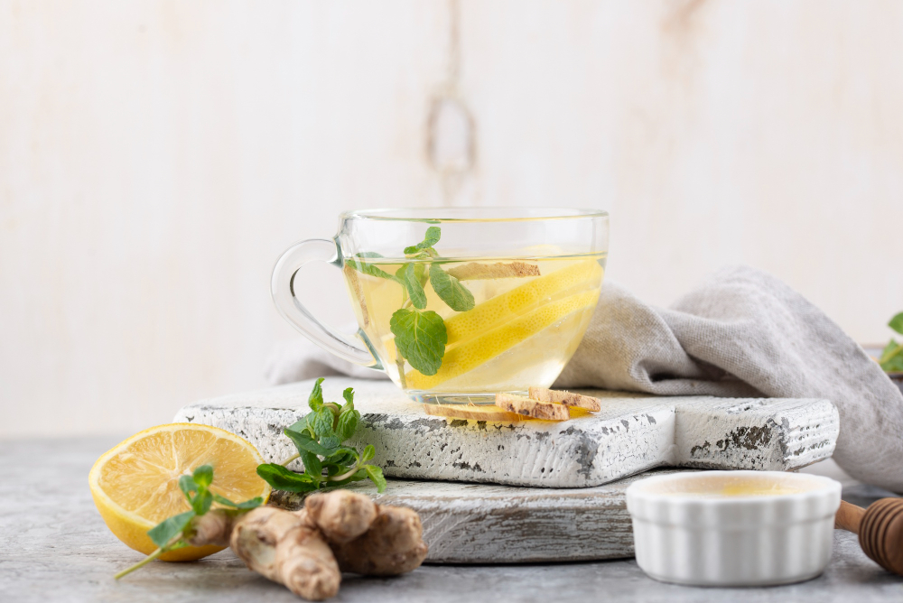 A cup of herbal tea with lemon slices, fresh mint leaves, and ginger, promoting Lemon Balm for Weight Loss benefits.